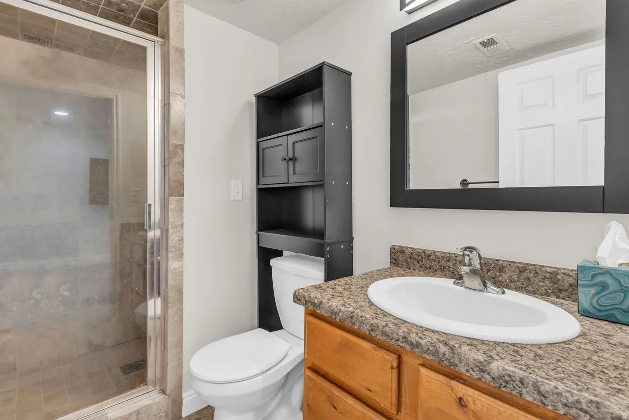 Basement bathroom with vanity and a tile shower stall