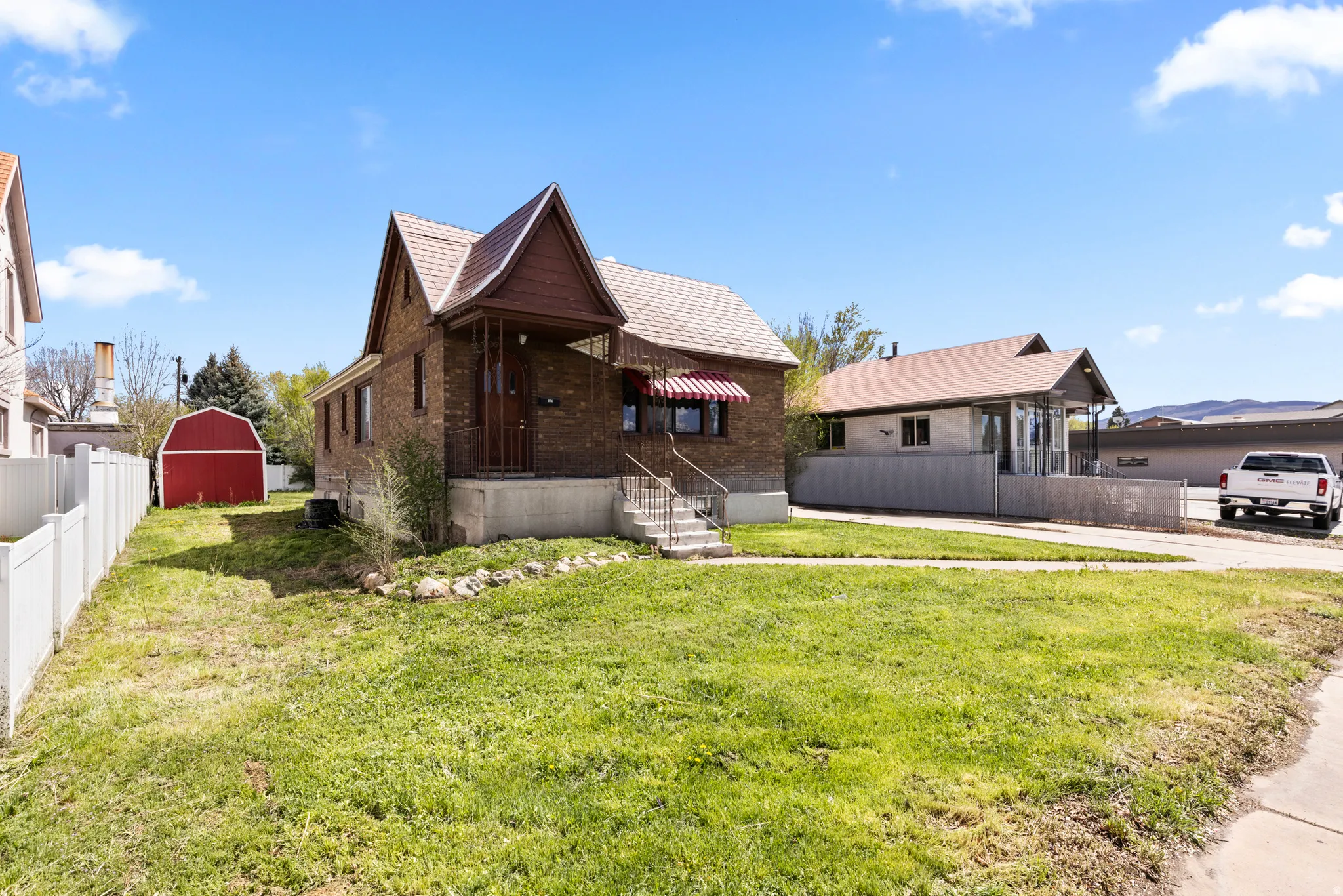 View of front facade featuring brick siding and an outdoor structure