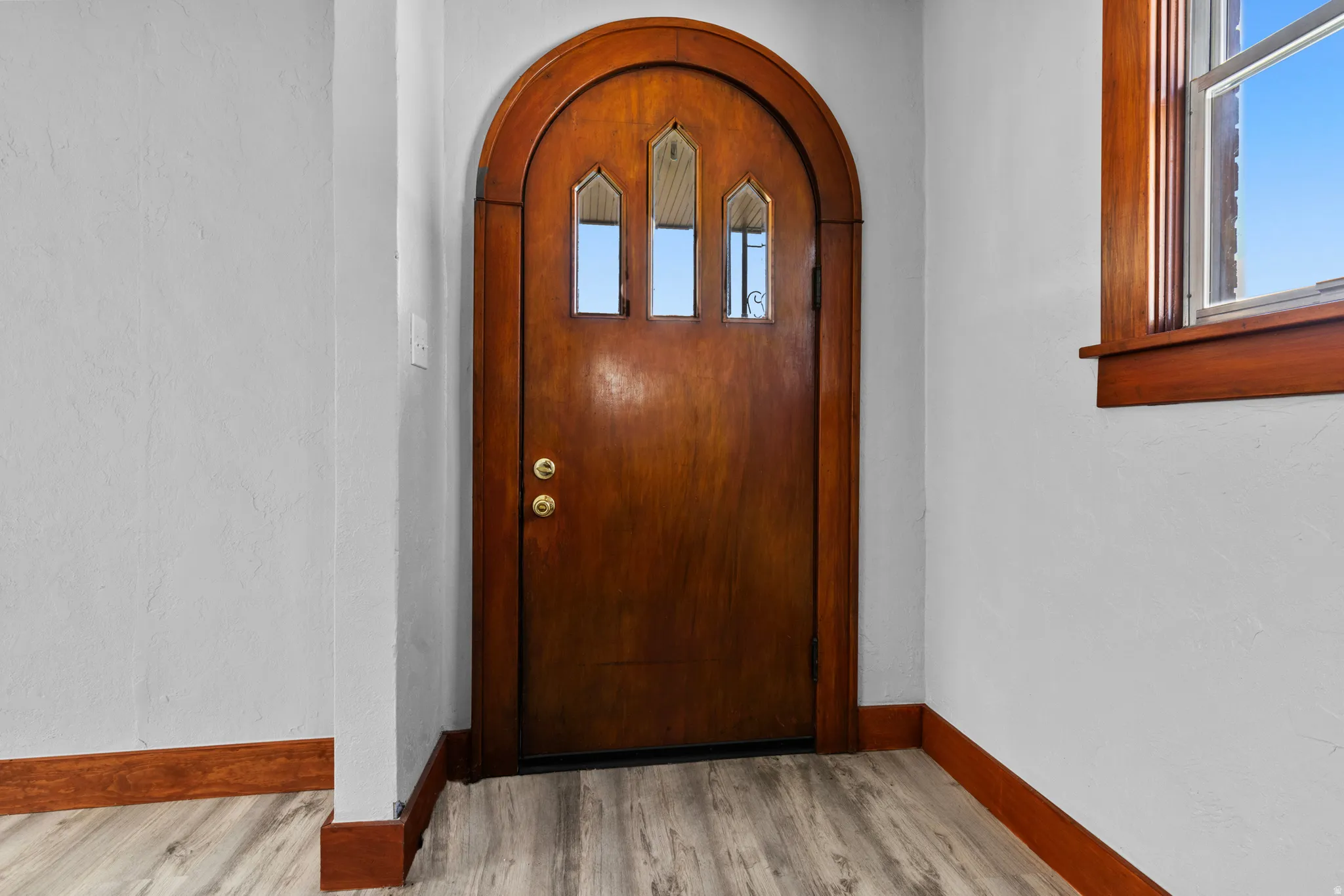 Entrance foyer featuring arched walkways and light wood-style flooring