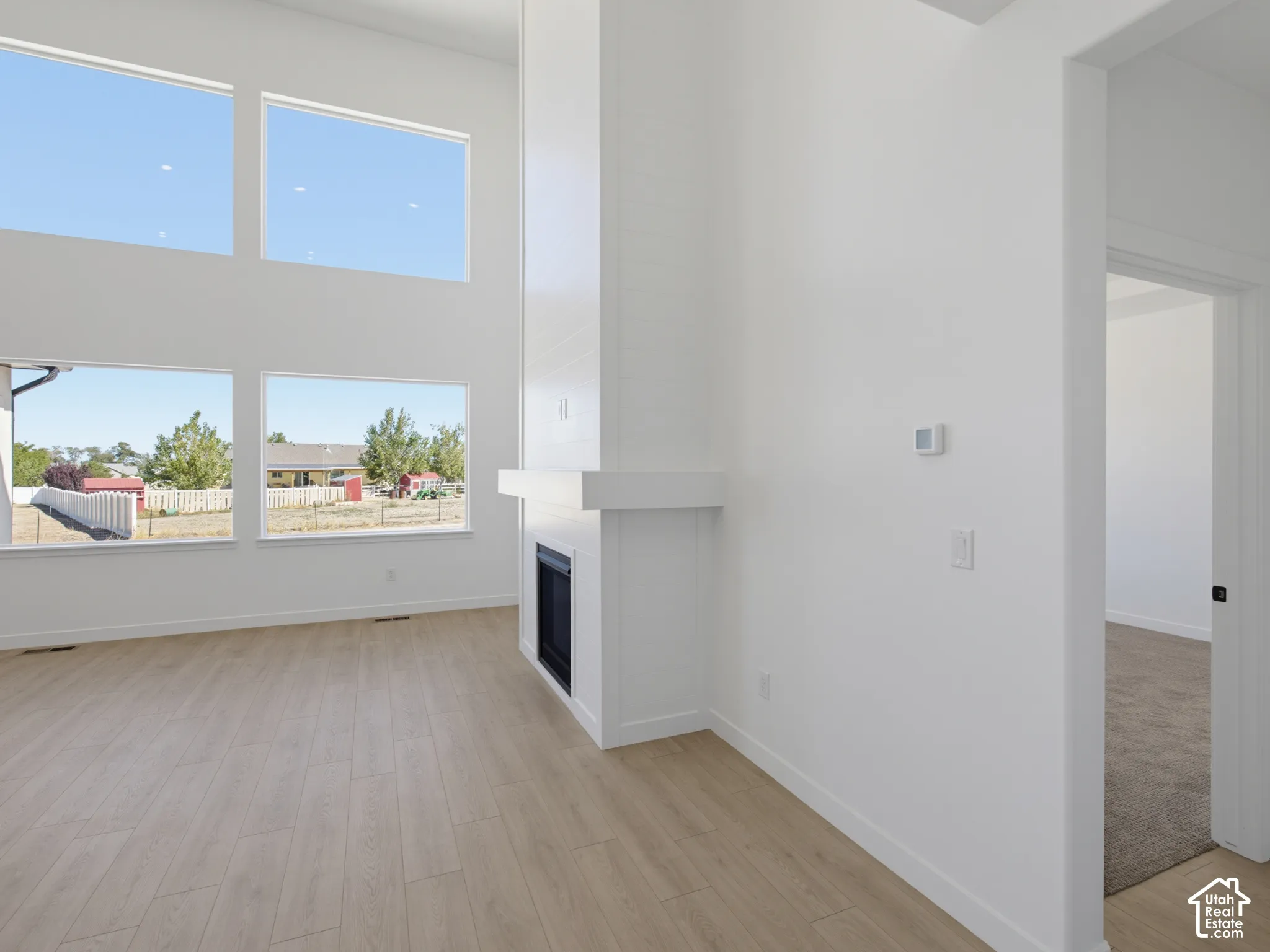 Expansive windows, wood-finish flooring, and a contemporary fireplace