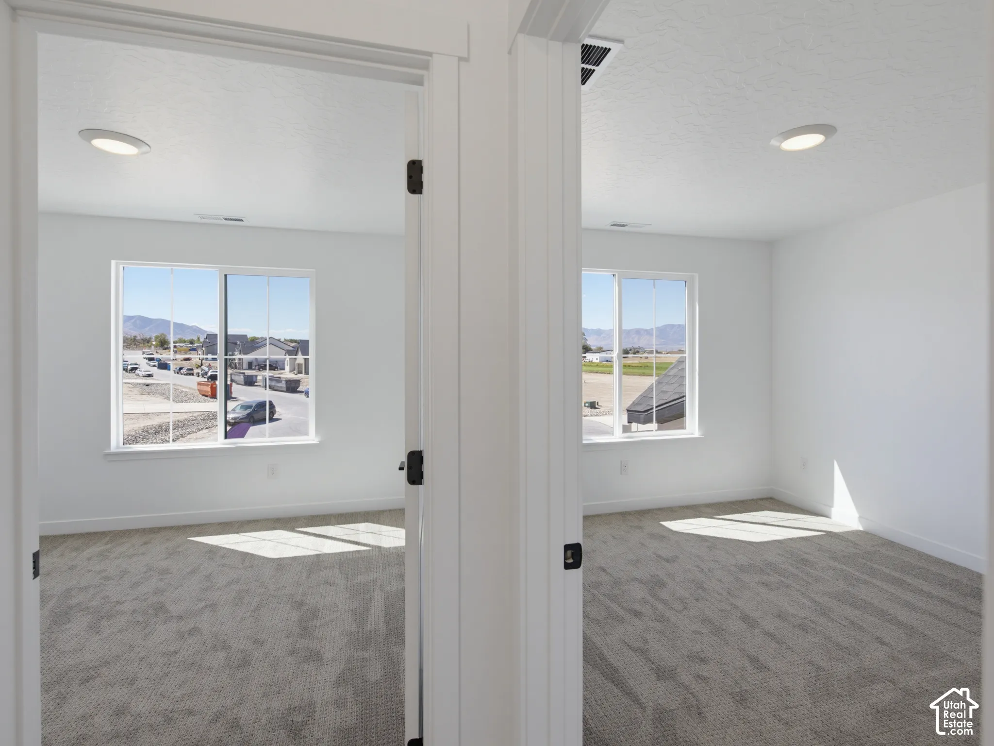 Rooms featuring neutral carpet, white walls, recessed ceiling lighting, and windows with mountain scenery