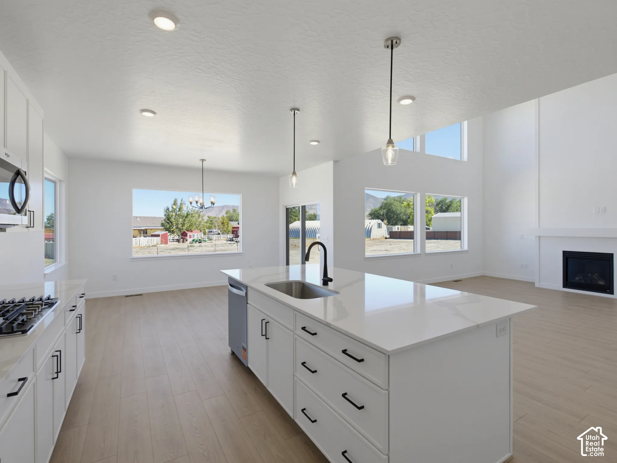 Spacious kitchen with a central island, integrated sink, and white cabinetry