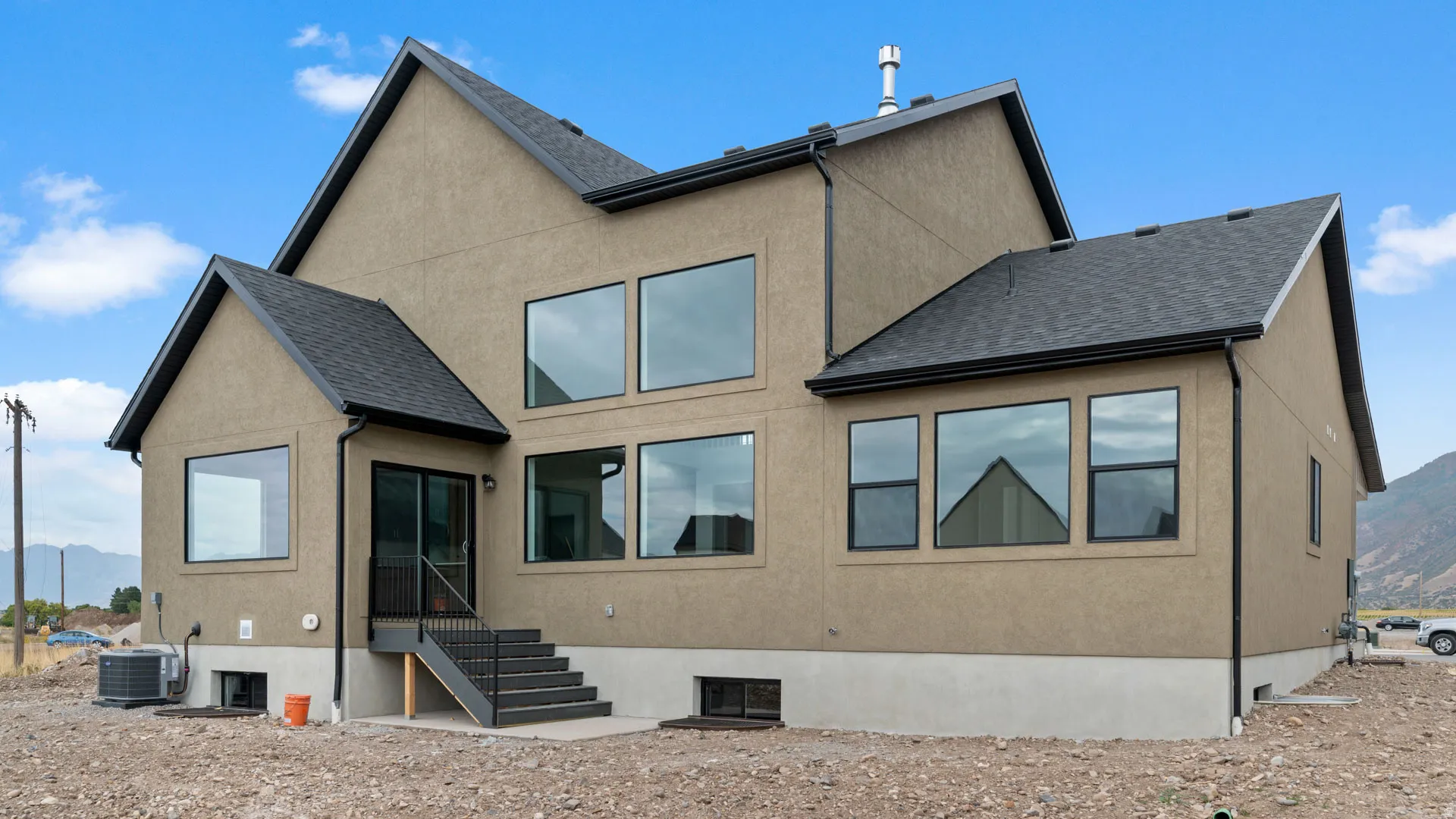 Contemporary exterior featuring a stucco finish and dark-framed windows