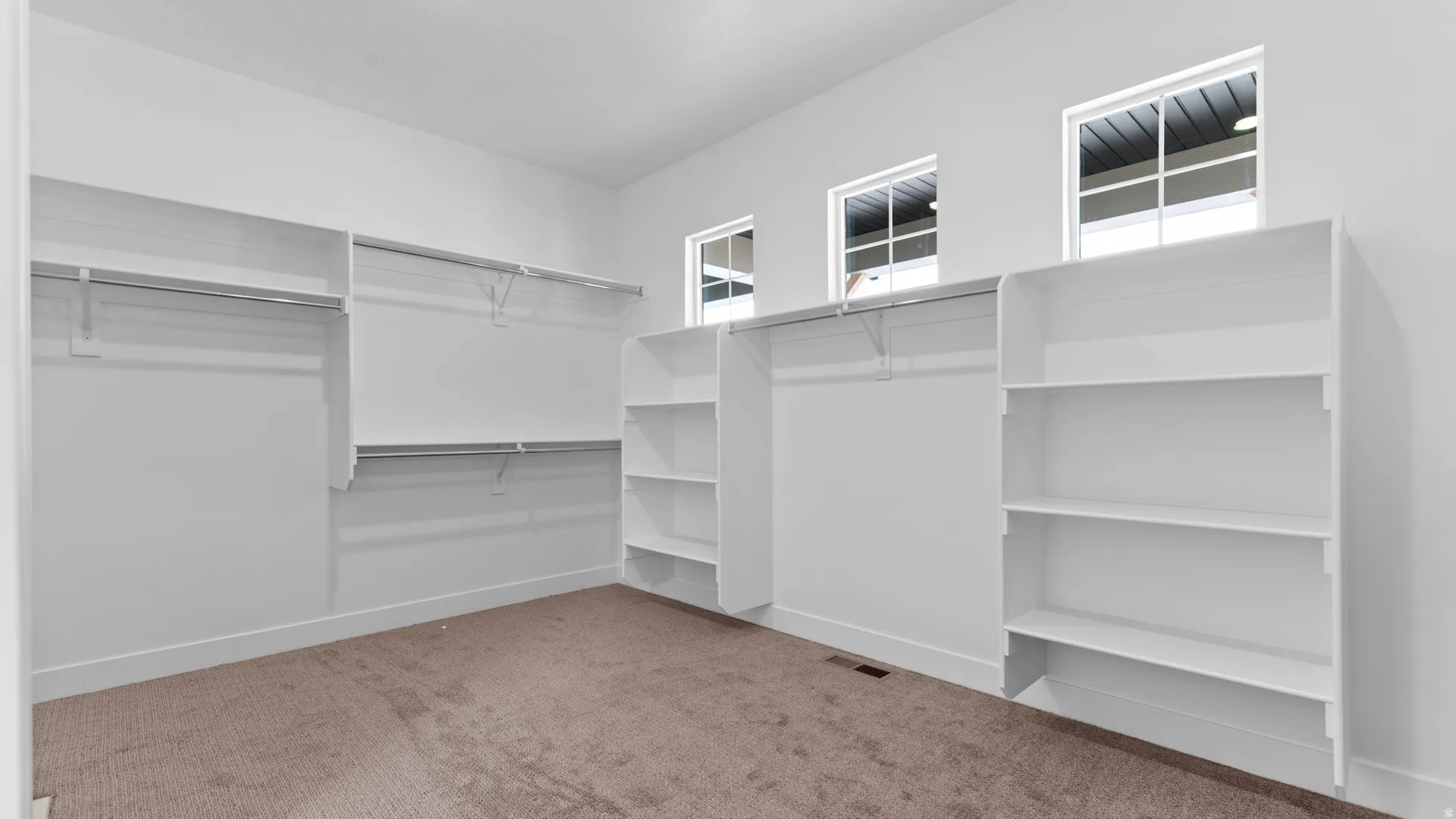 Built-in closet organization system featuring multiple shelving units and hanging rods