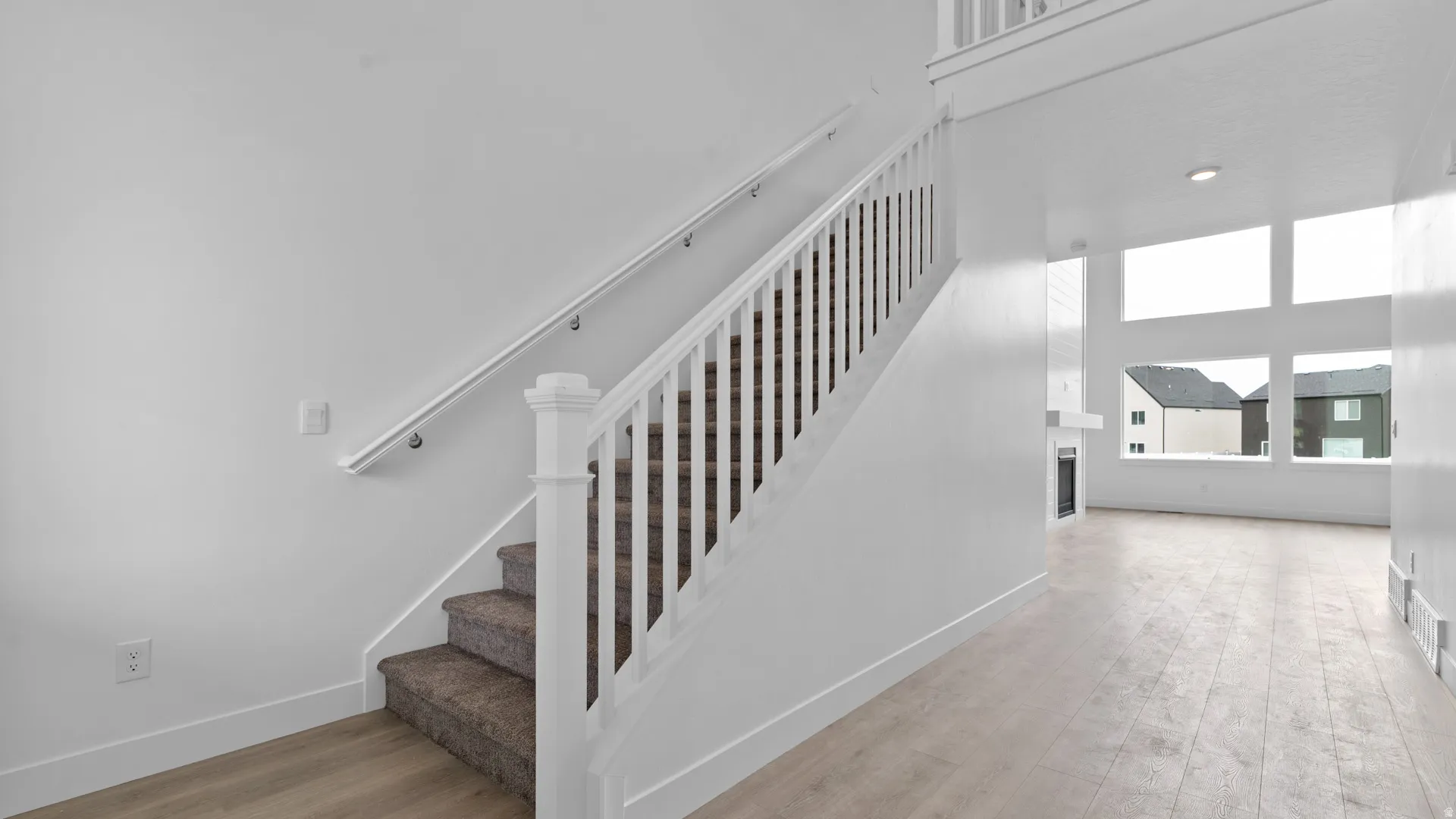 Carpeted staircase with white balusters and handrail