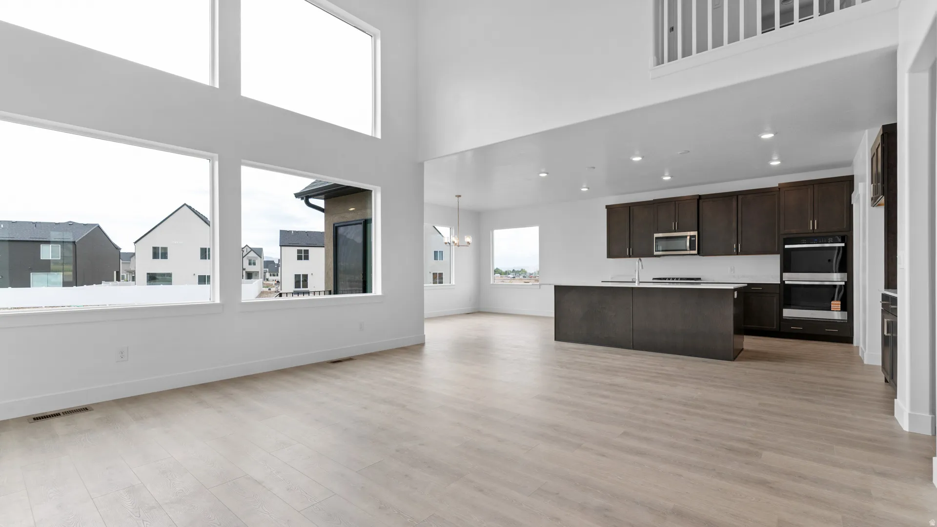 Spacious open-concept living area featuring vaulted ceilings and extensive window placements