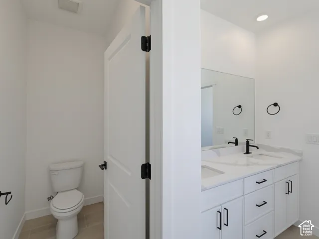 Dual vanity with white cabinetry, matte black hardware, and an integrated countertop