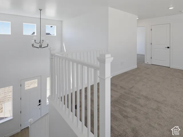 Carpeted upper landing with white paneled doors and recessed lighting