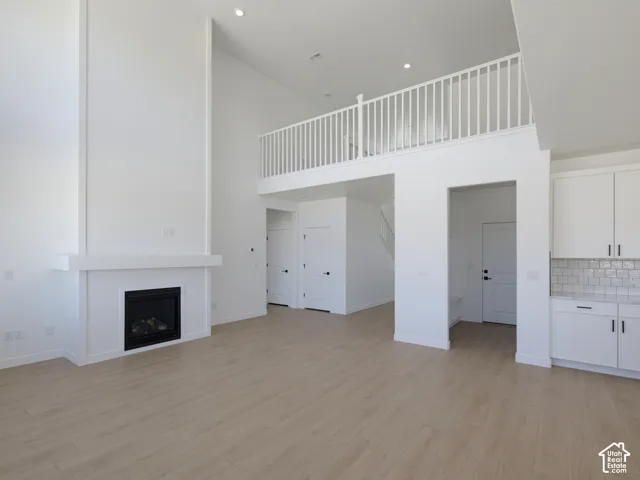 Vaulted ceilings, a built-in fireplace, wood-finish flooring, an open loft, and a kitchen featuring subway tile backsplash
