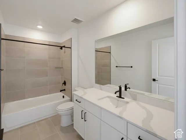 White vanity with integrated sink, black fixtures, and a large mirror