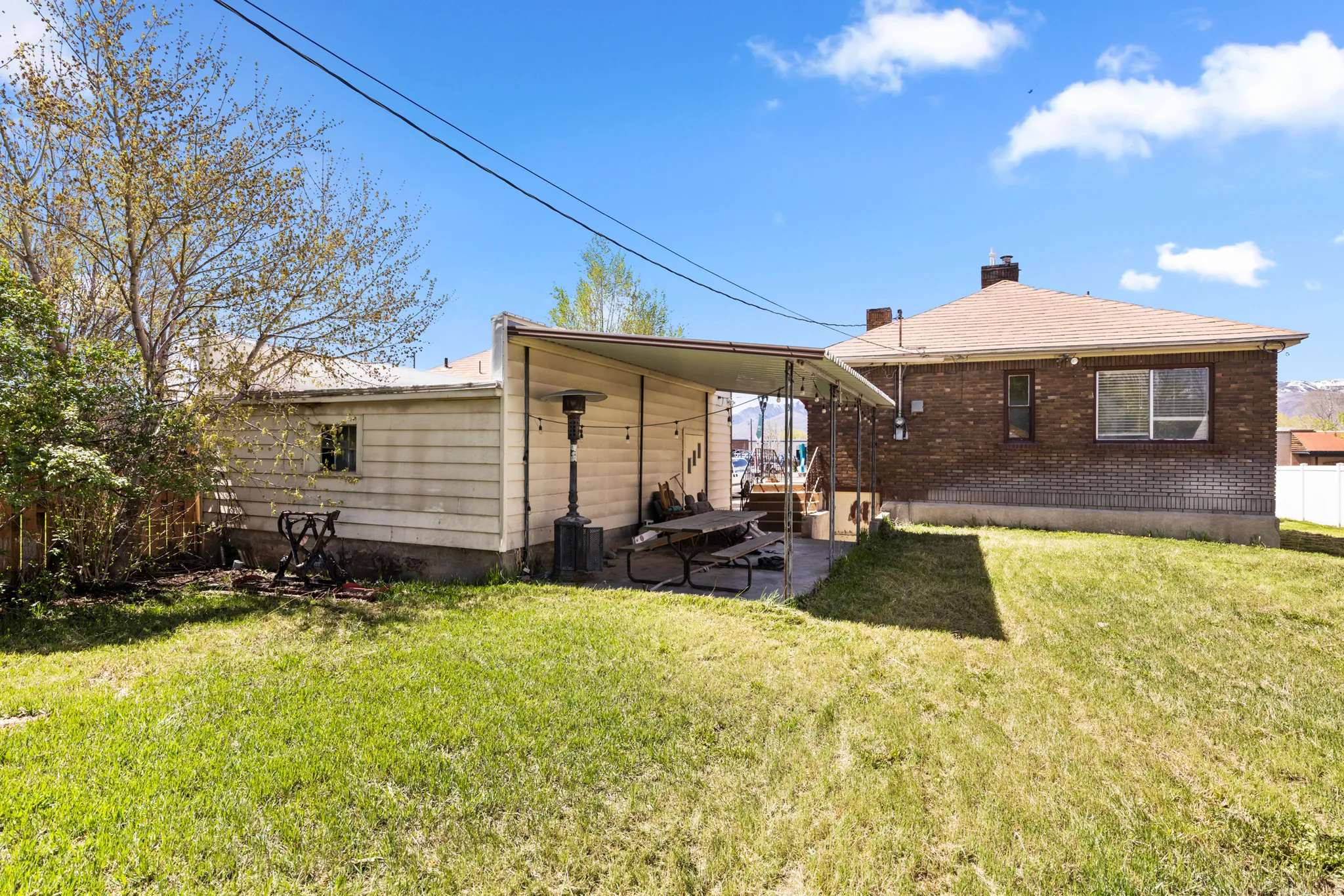 Back of house featuring a yard, a chimney, and brick siding