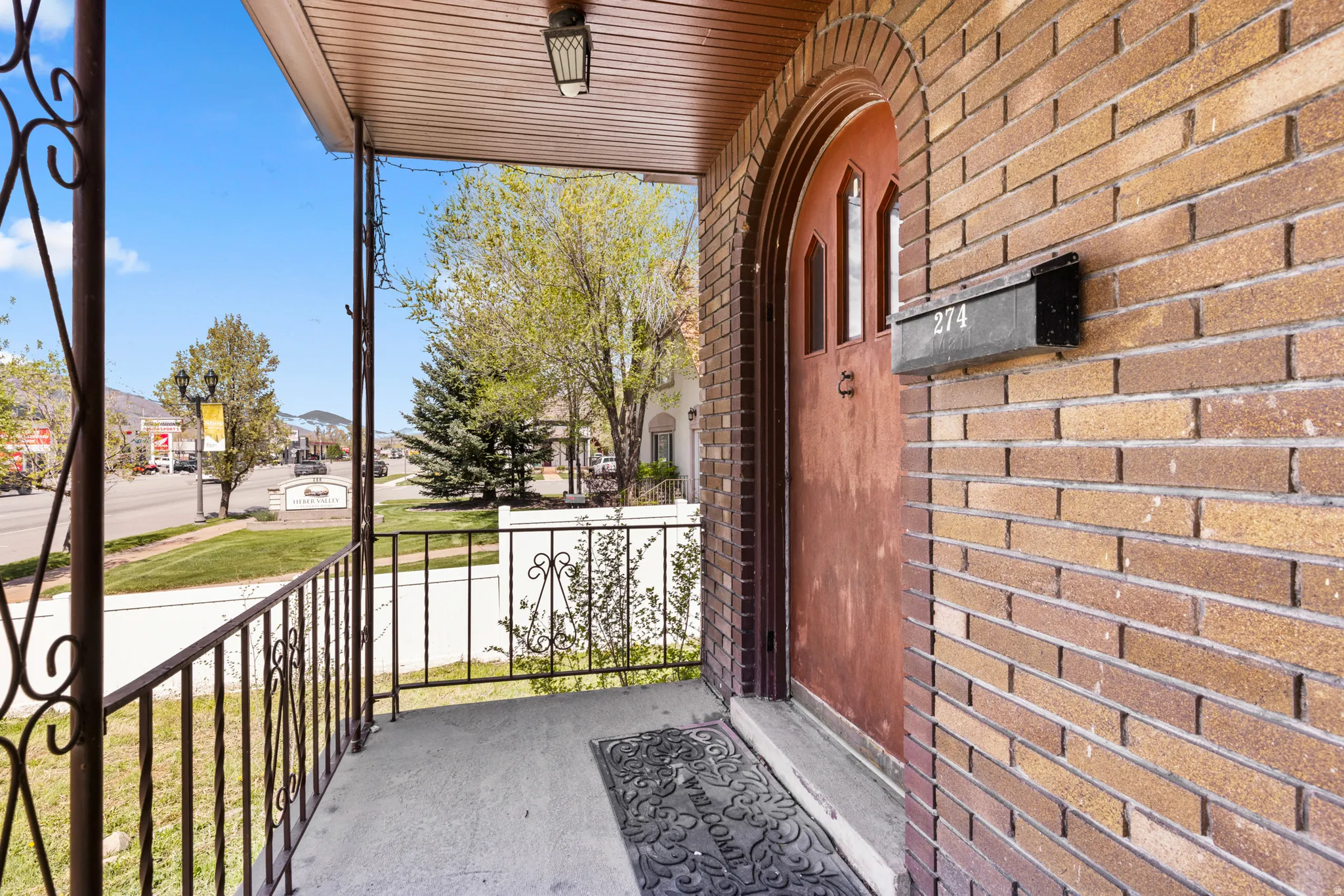 Property entrance with a porch and brick siding