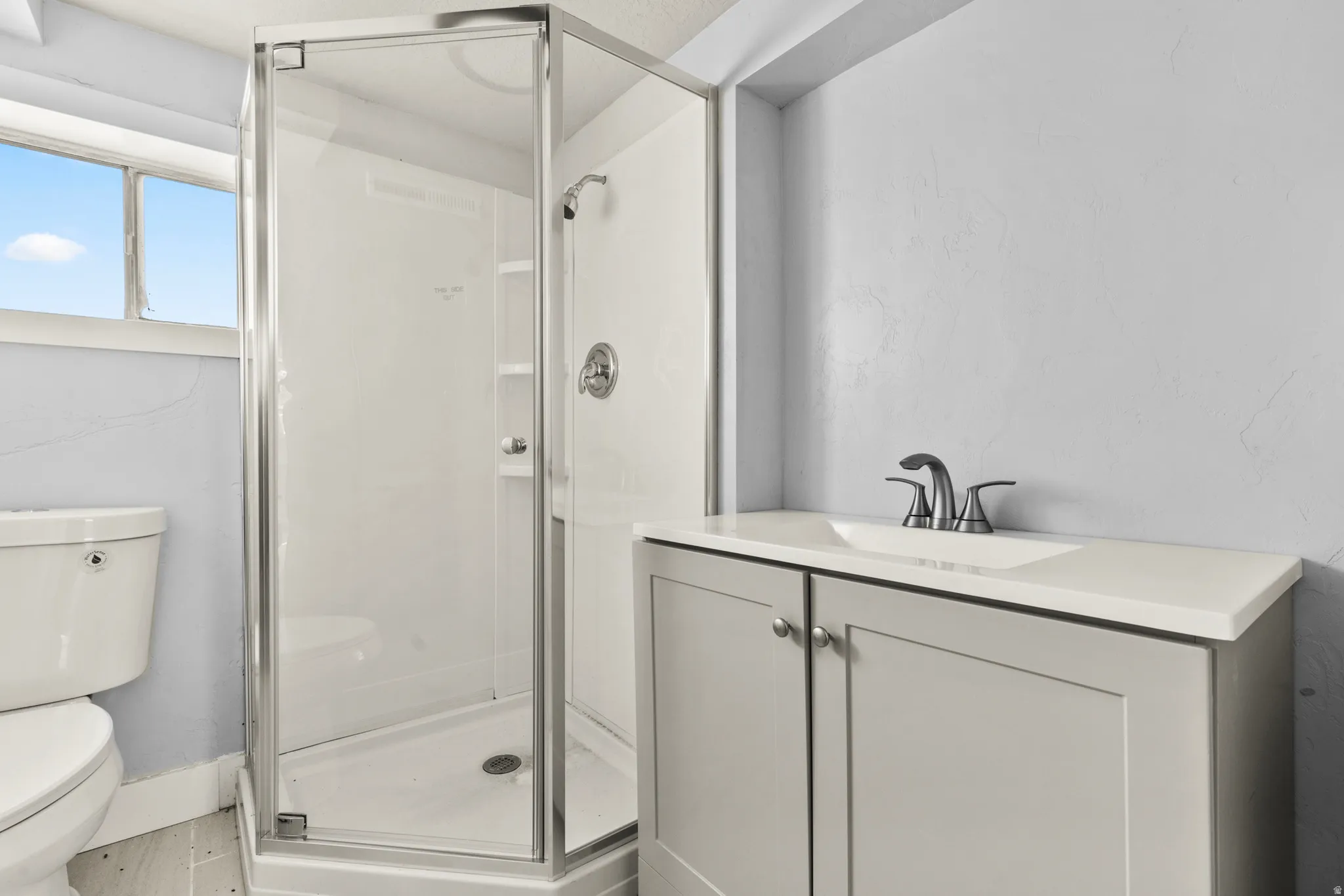 Full bath featuring vanity and a shower stall