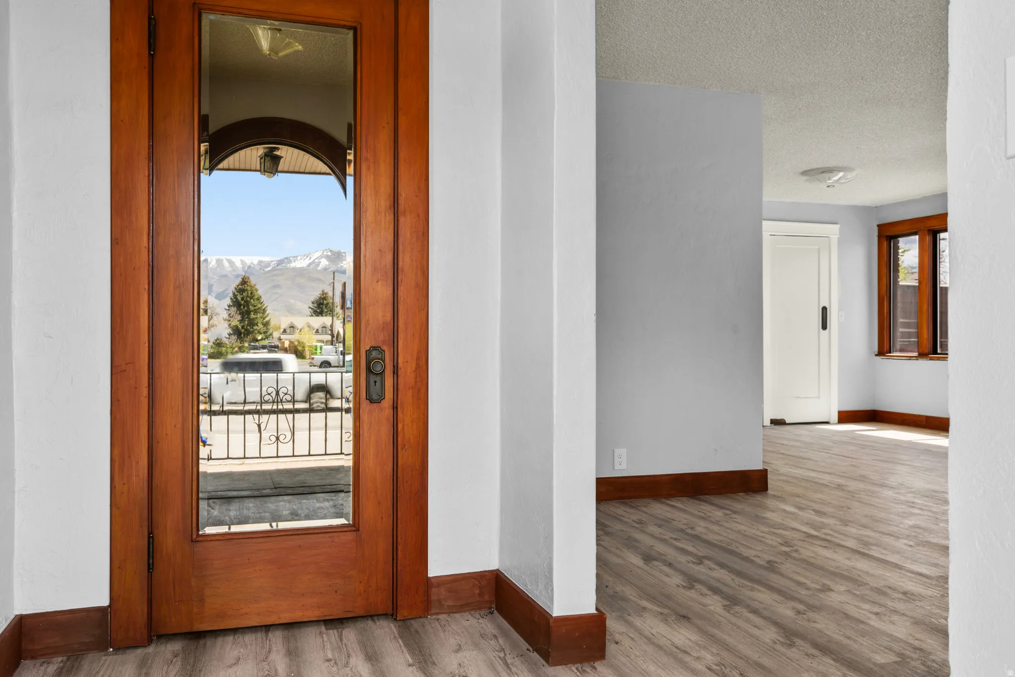 Doorway with wood finished floors, a mountain view, and a textured ceiling