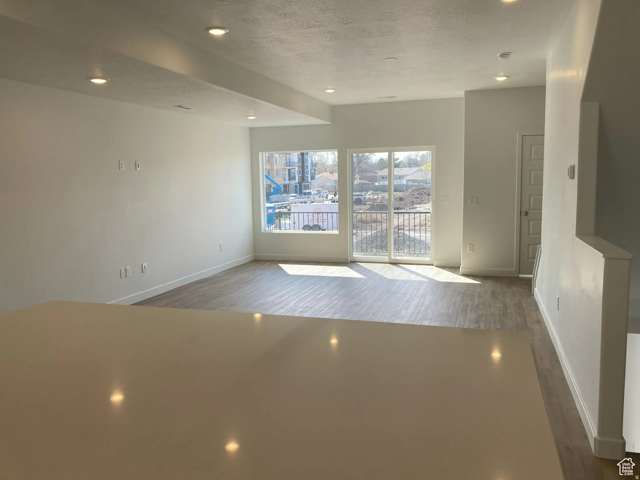 Empty room featuring recessed lighting, light wood-style flooring, and a textured ceiling