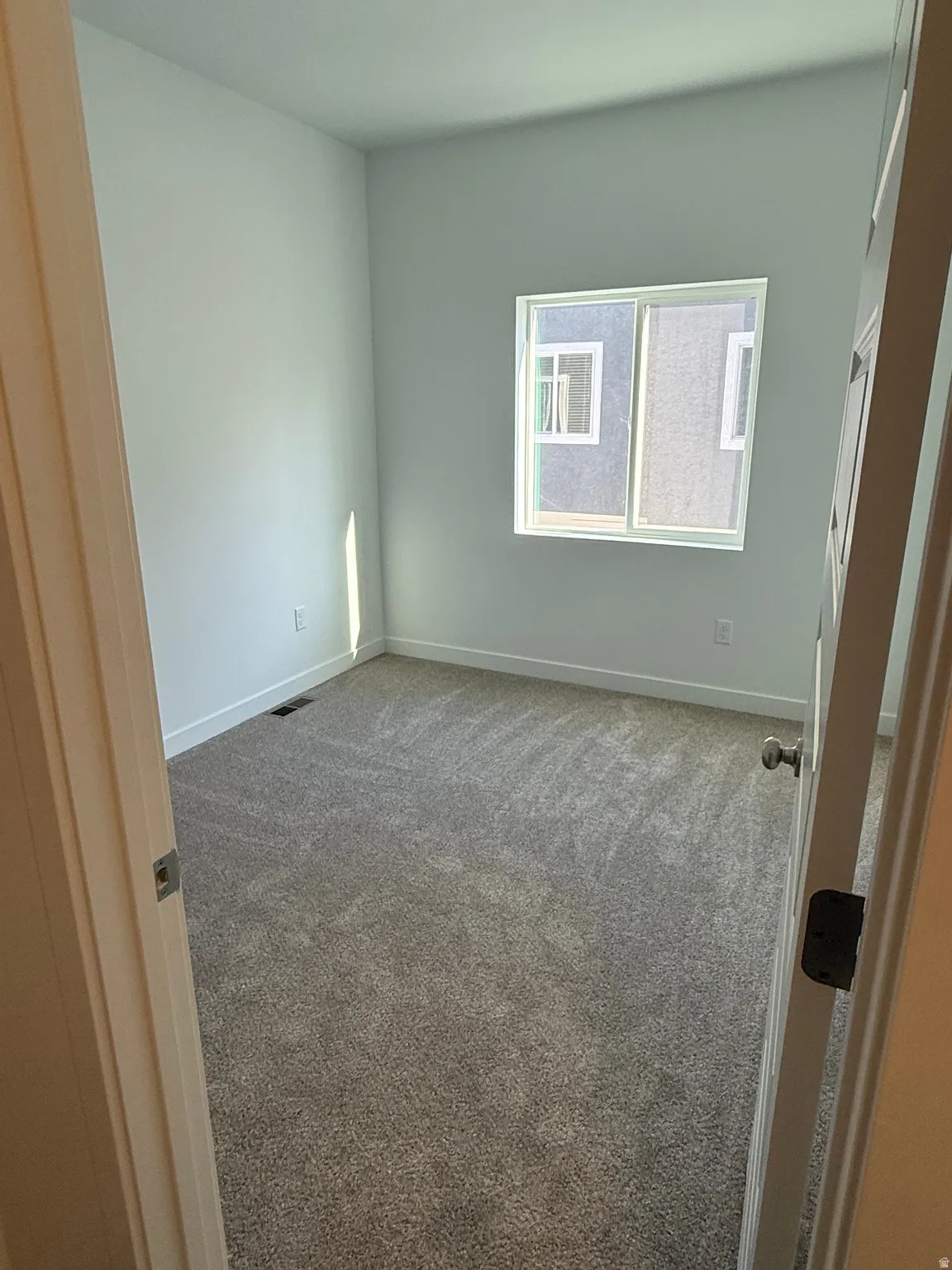 Carpeted spare room with baseboards