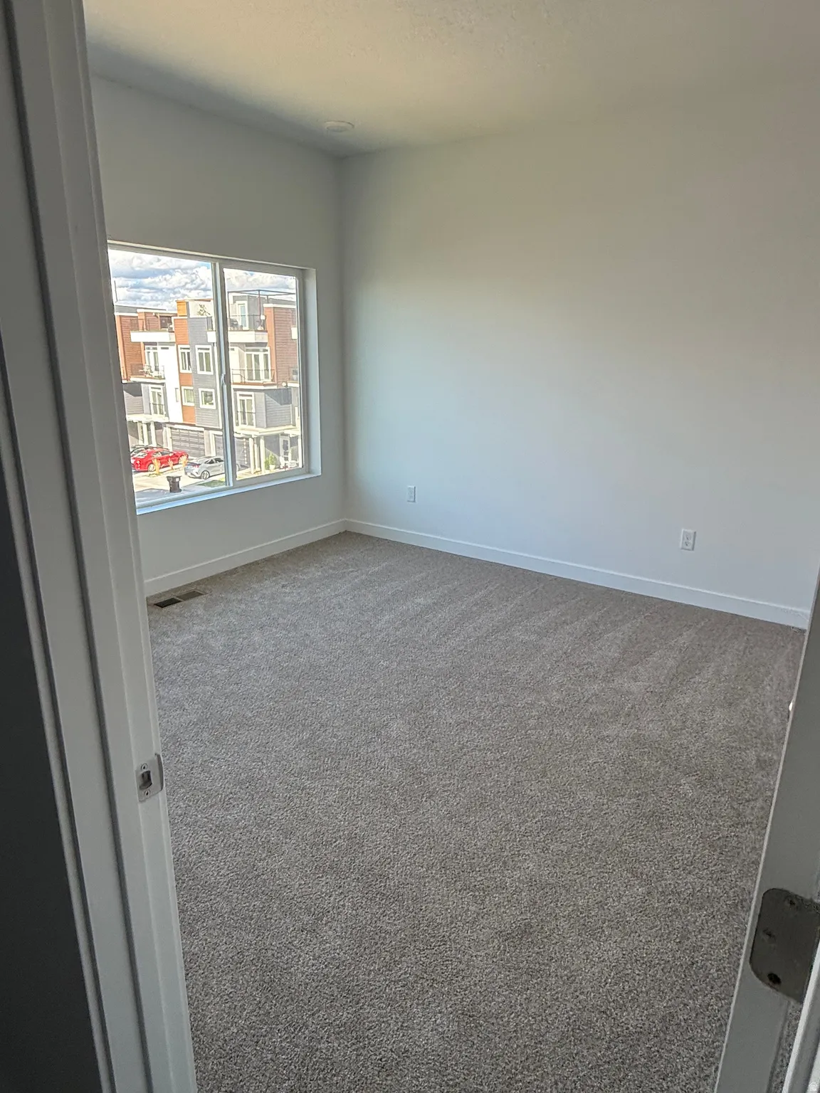 Spare room with dark carpet and baseboards