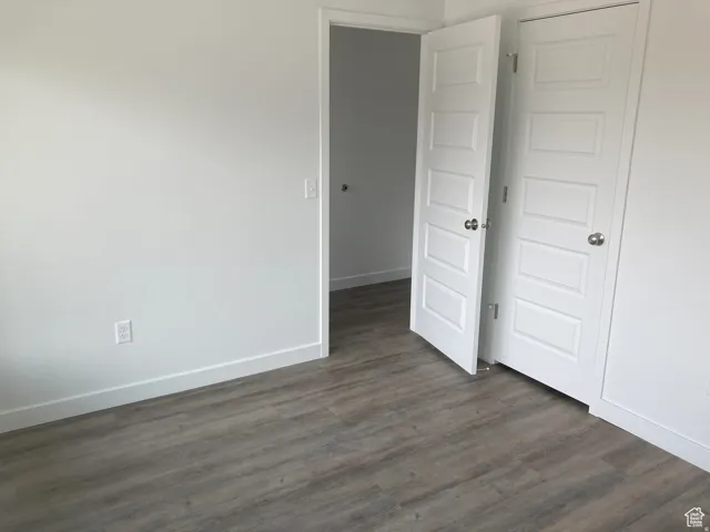 Empty room with dark wood-type flooring