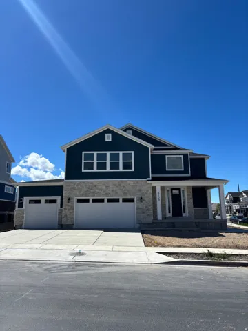 View of front of house featuring stone siding, covered porch, concrete driveway, and a garage