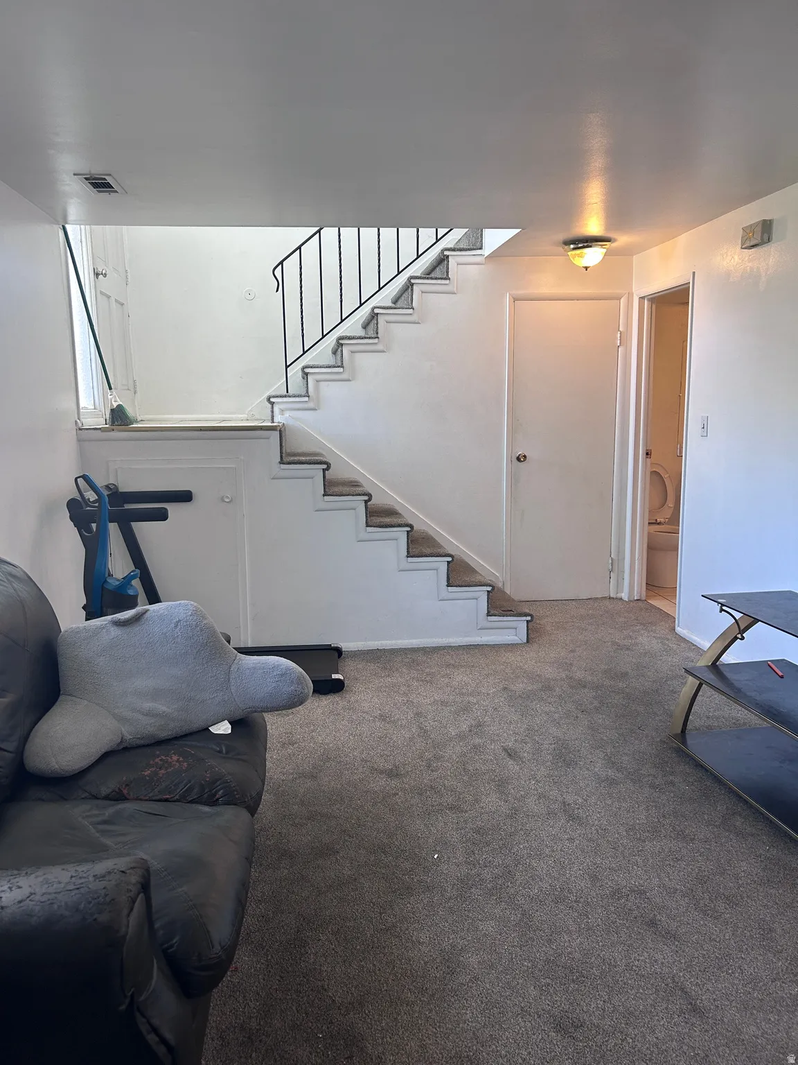 Carpeted living area featuring stairs
