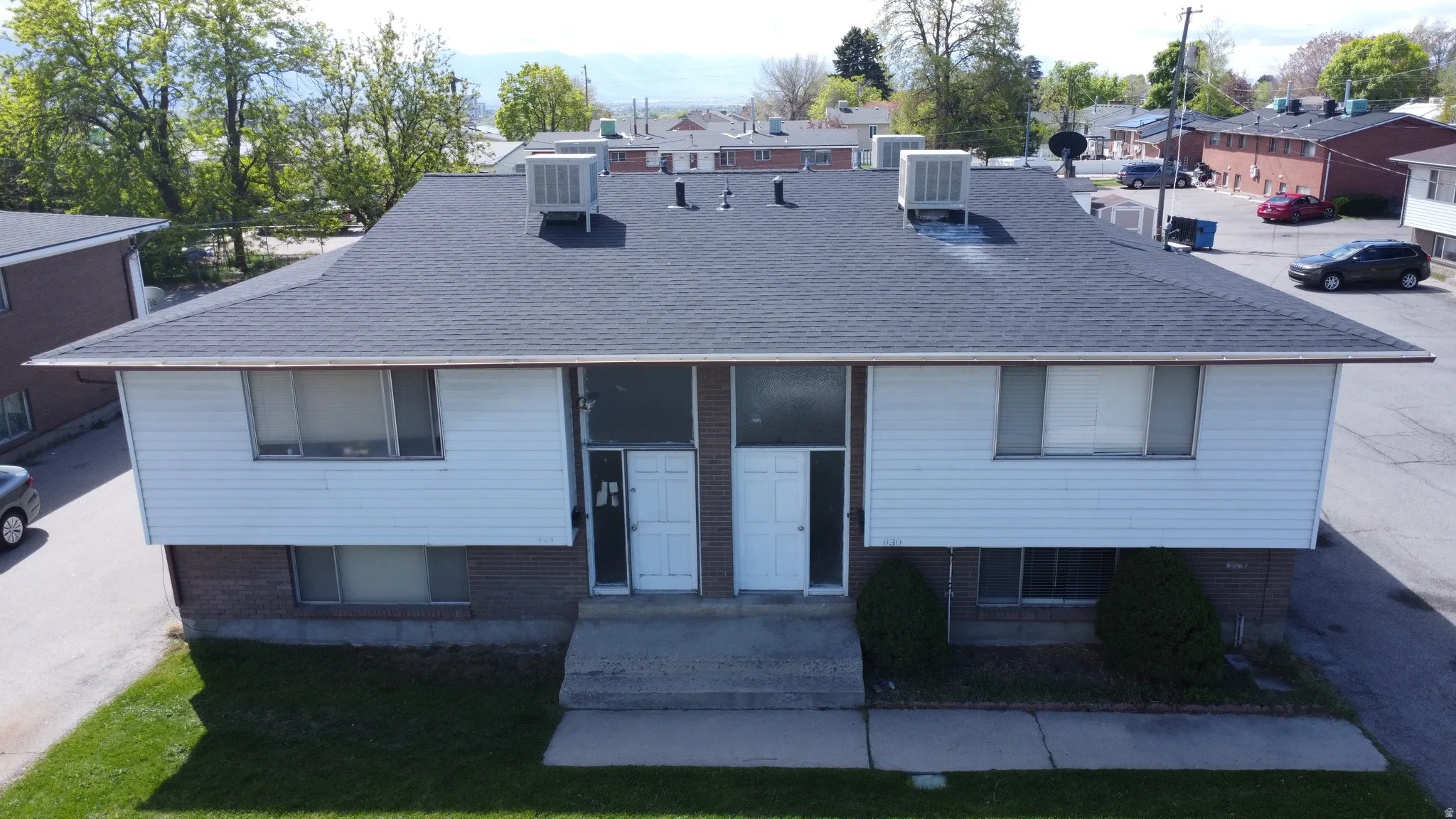 Split foyer home with brick siding and roof with shingles