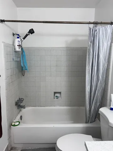 Bathroom with shower / tub combo with curtain and vanity