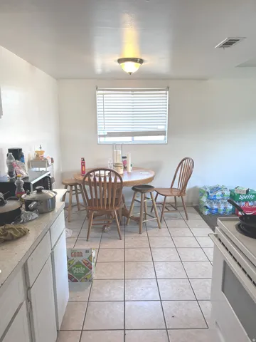 Dining space with light tile patterned flooring