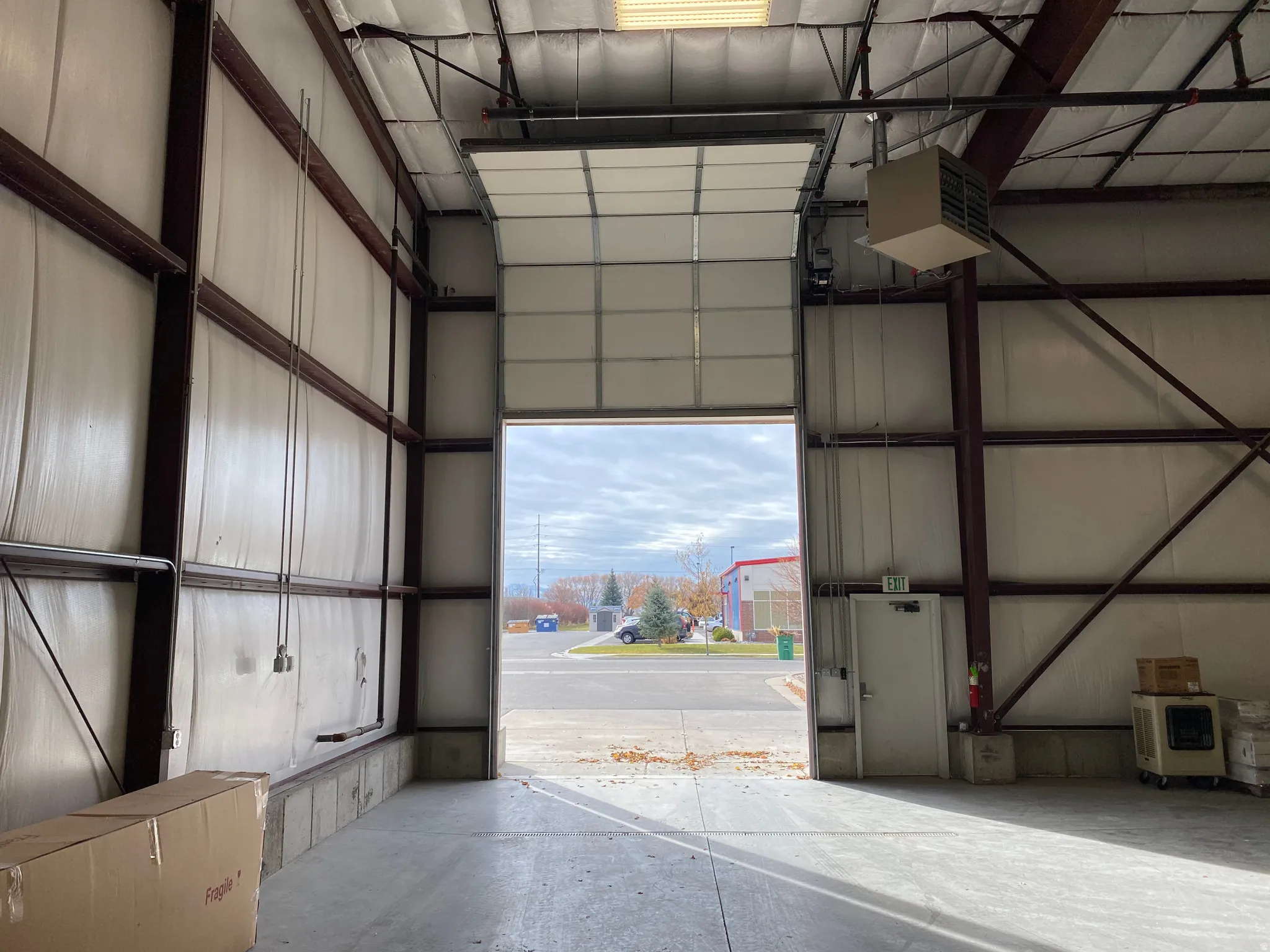 Garage featuring a heating unit, metal wall, and heating unit