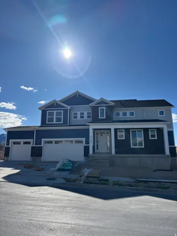 View of front facade featuring driveway, a porch, and a garage