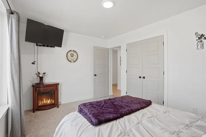 Bedroom featuring light colored carpet and a closet