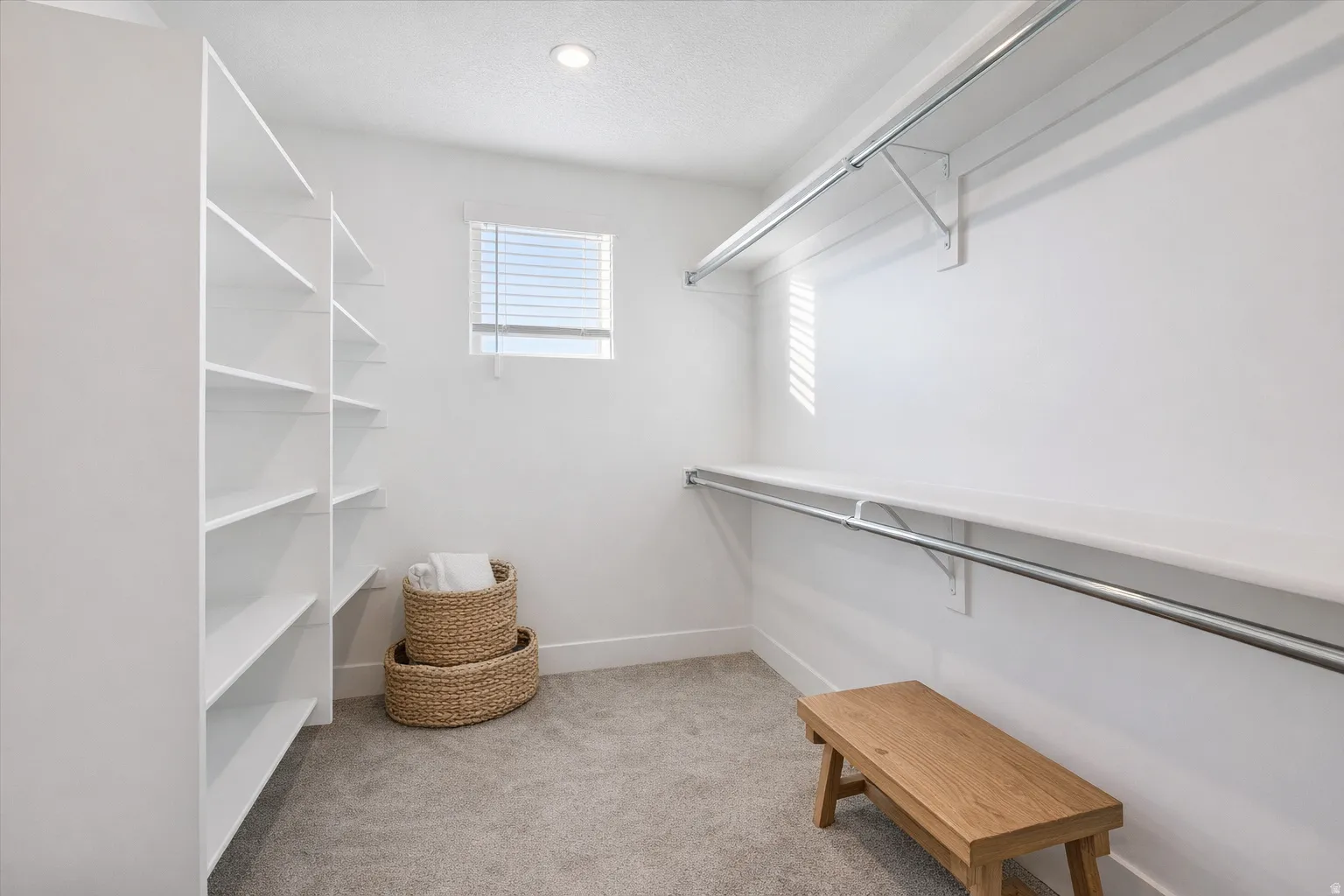 Walk in closet featuring light colored carpet