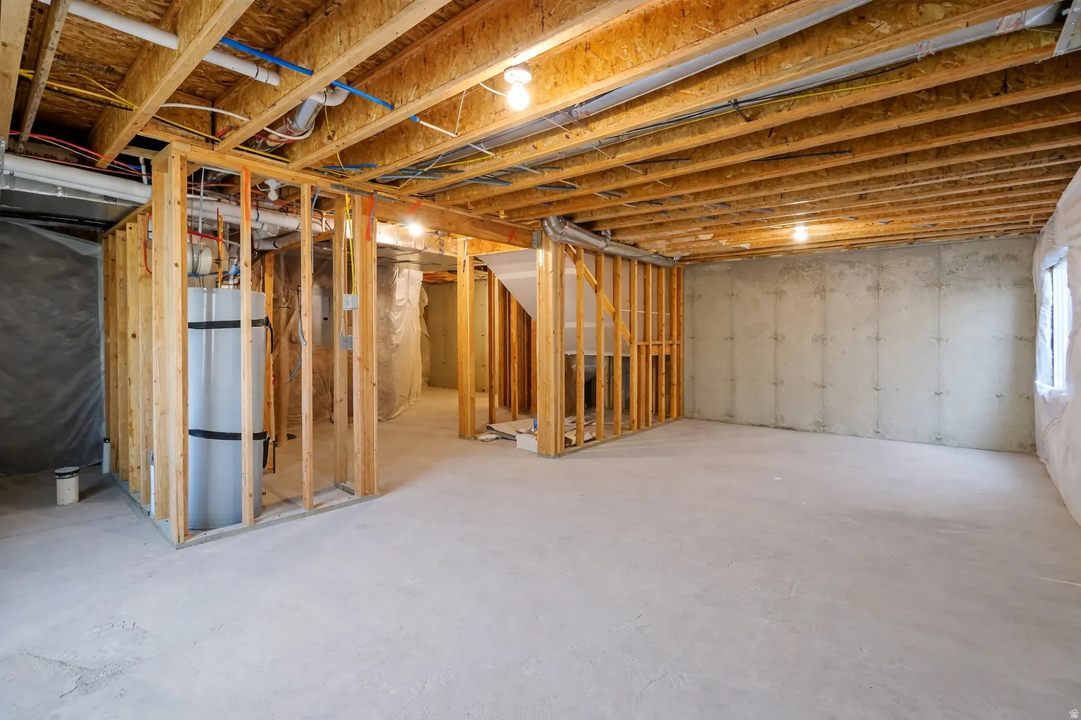Basement featuring strapped water heater