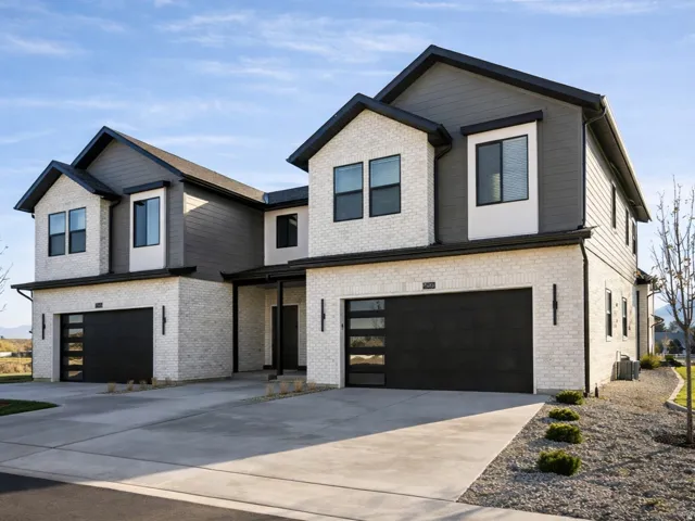 Modern home featuring a garage, brick siding, concrete driveway, and a mountain view