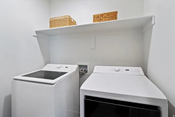Dedicated laundry area featuring white walls and a white built-in shelf