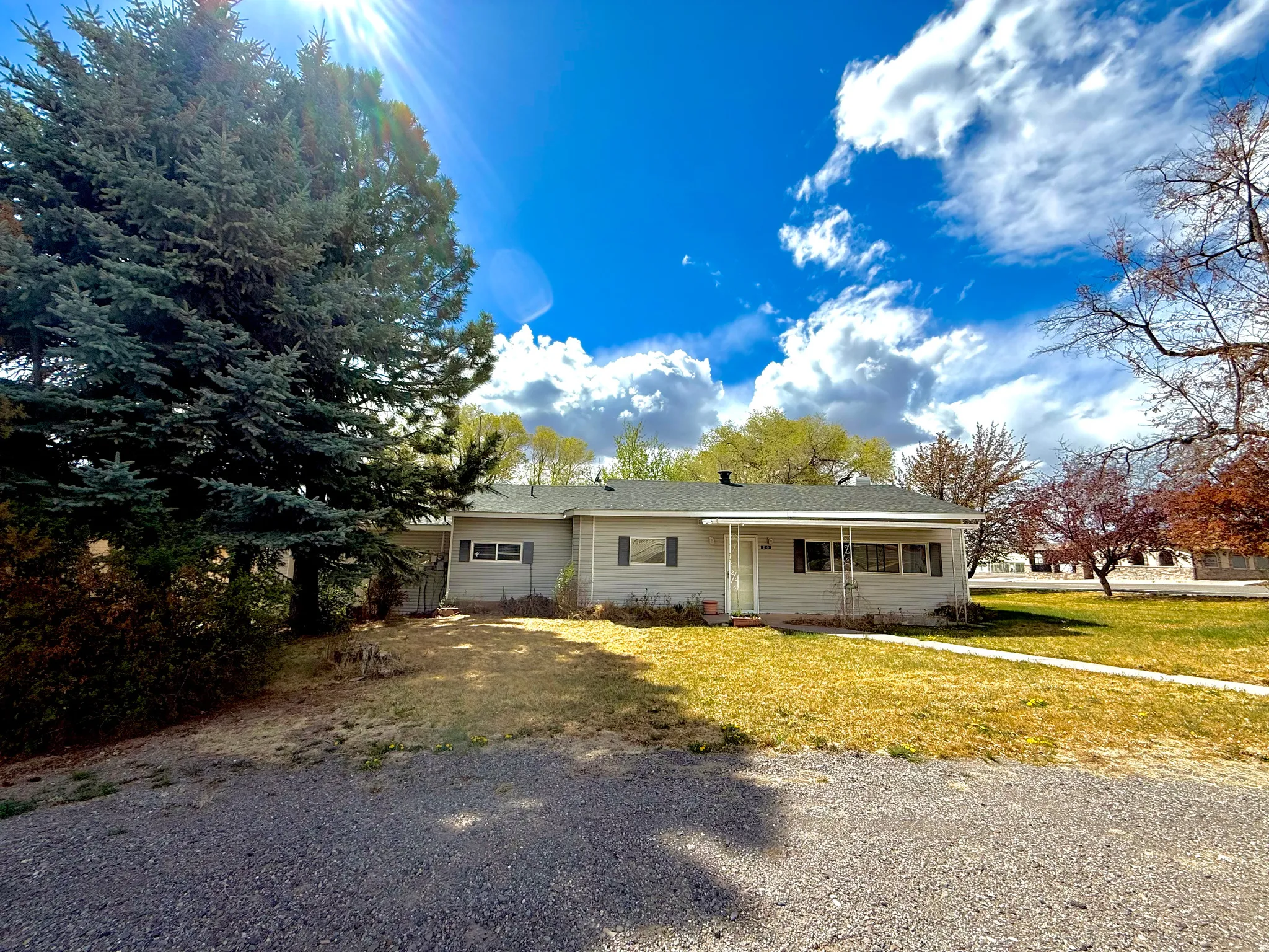 Single story home featuring a porch and a front lawn