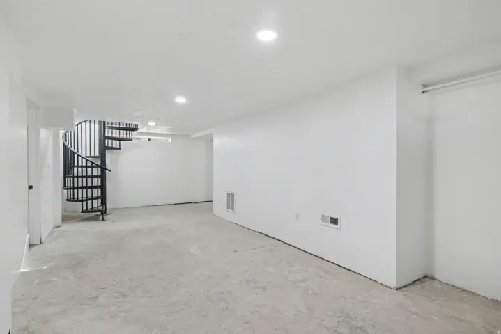 Finished below grade area featuring stairway and recessed lighting