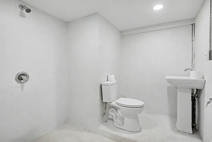 Bathroom with a shower, concrete floors, and recessed lighting