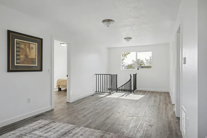 Empty room featuring dark wood-style floors and baseboards