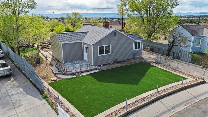 View of front of home featuring roof with shingles, a fenced backyard, and a patio area