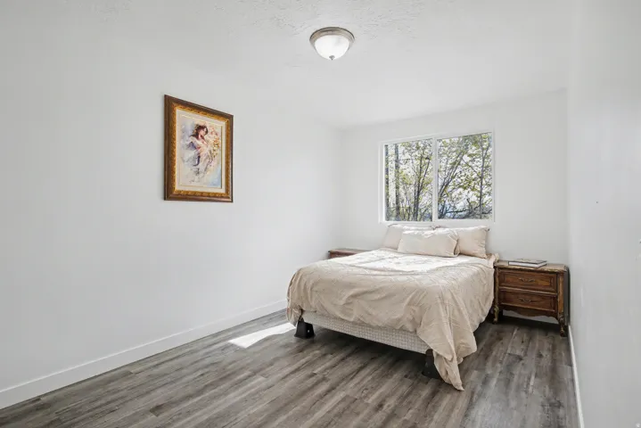 Bedroom featuring wood finished floors and baseboards