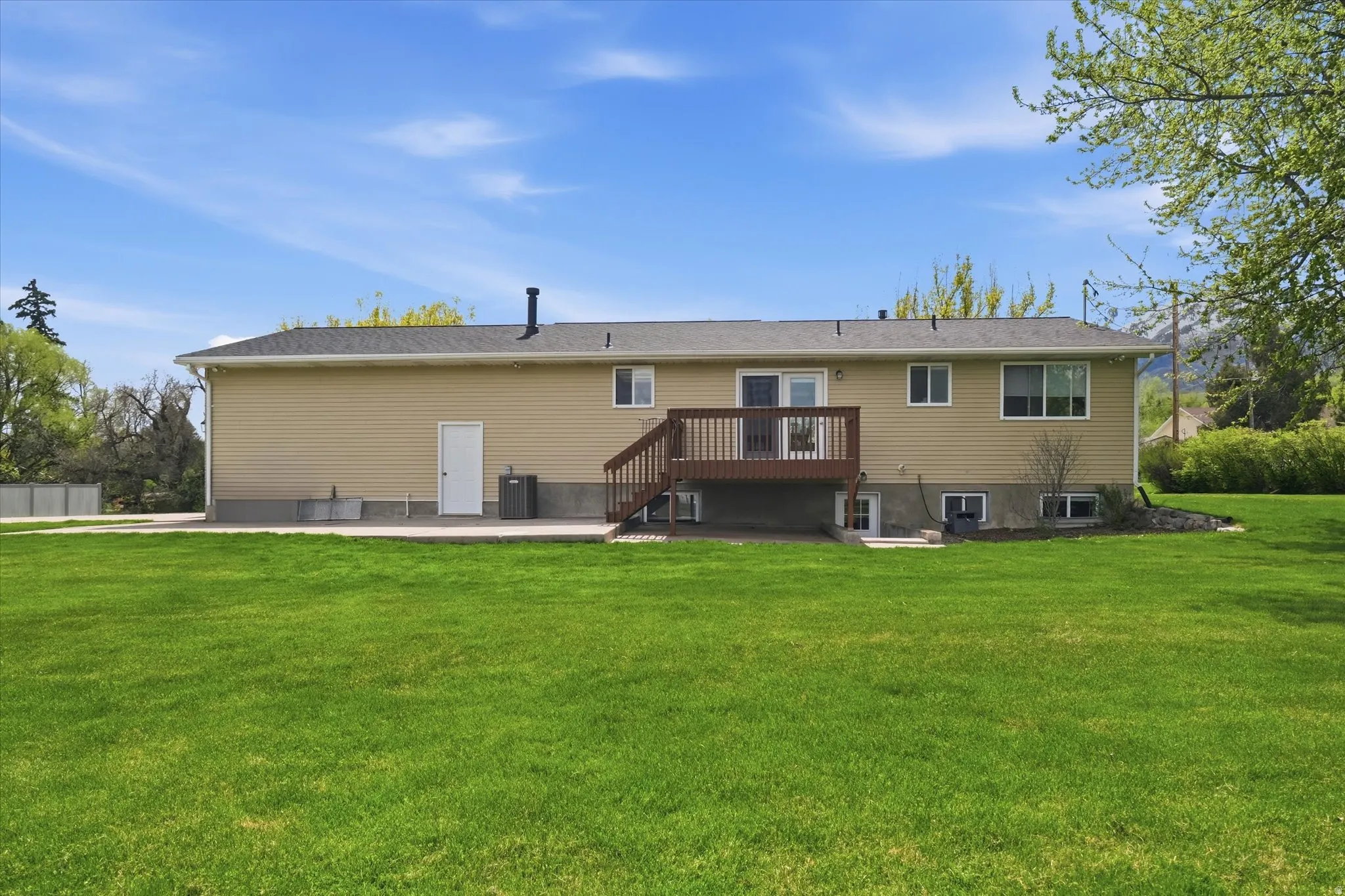 Back of house with a patio, a yard, and a wooden deck