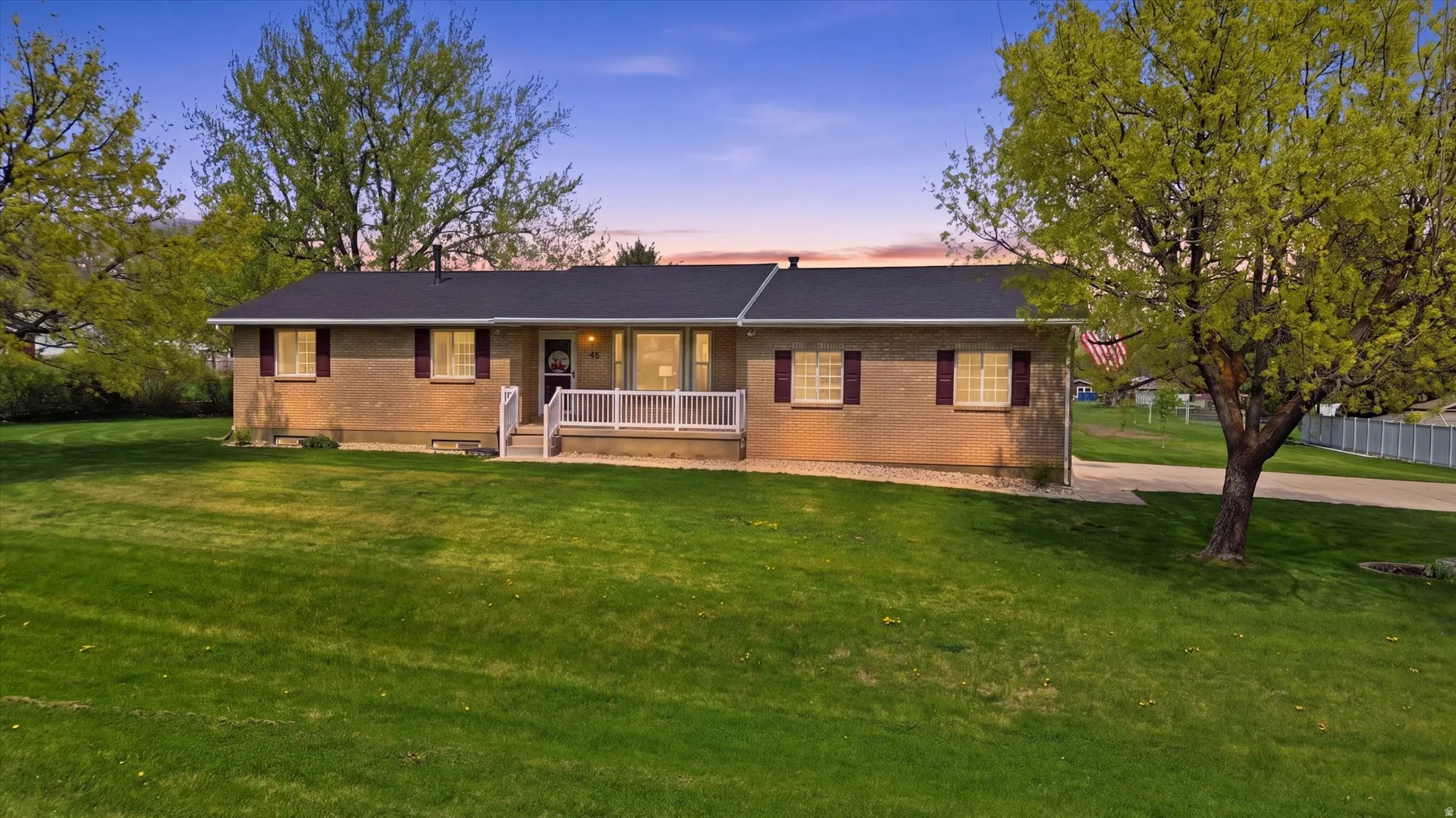 Ranch-style house with brick siding, a yard, and a porch