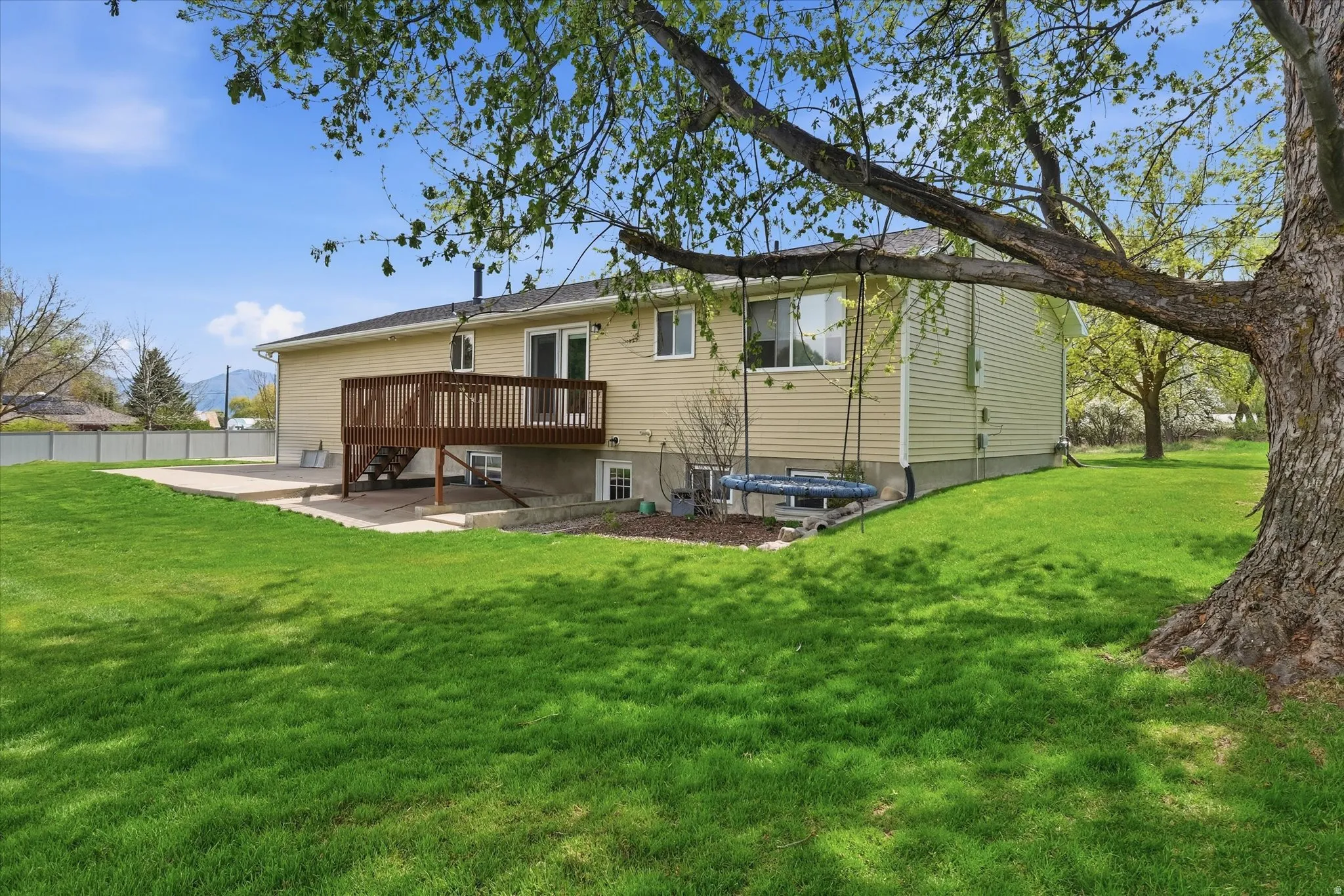 Rear view of property with a lawn and a wooden deck