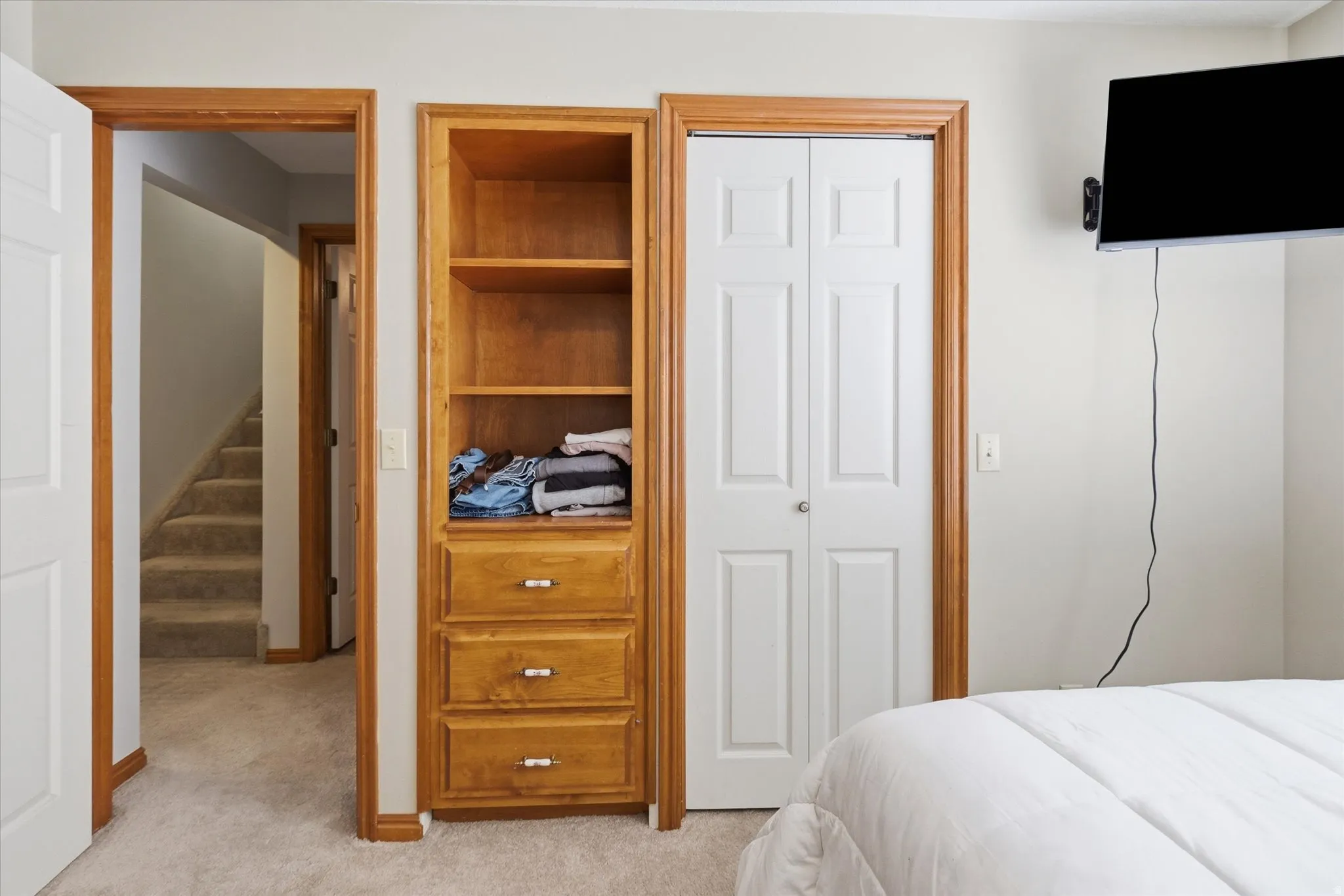 Bedroom with light colored carpet and a closet
