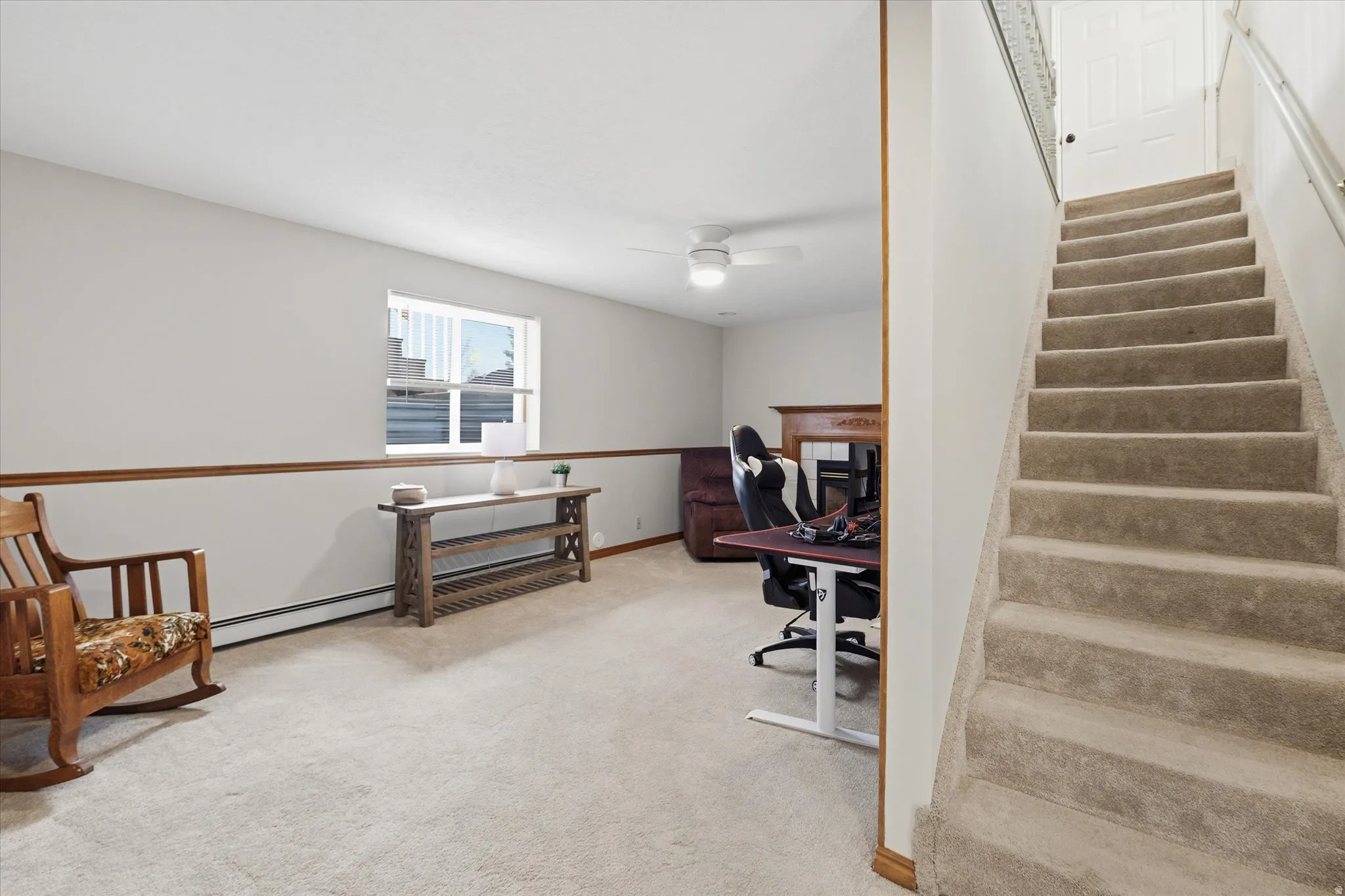 Office with light carpet, a ceiling fan, and a baseboard heating unit