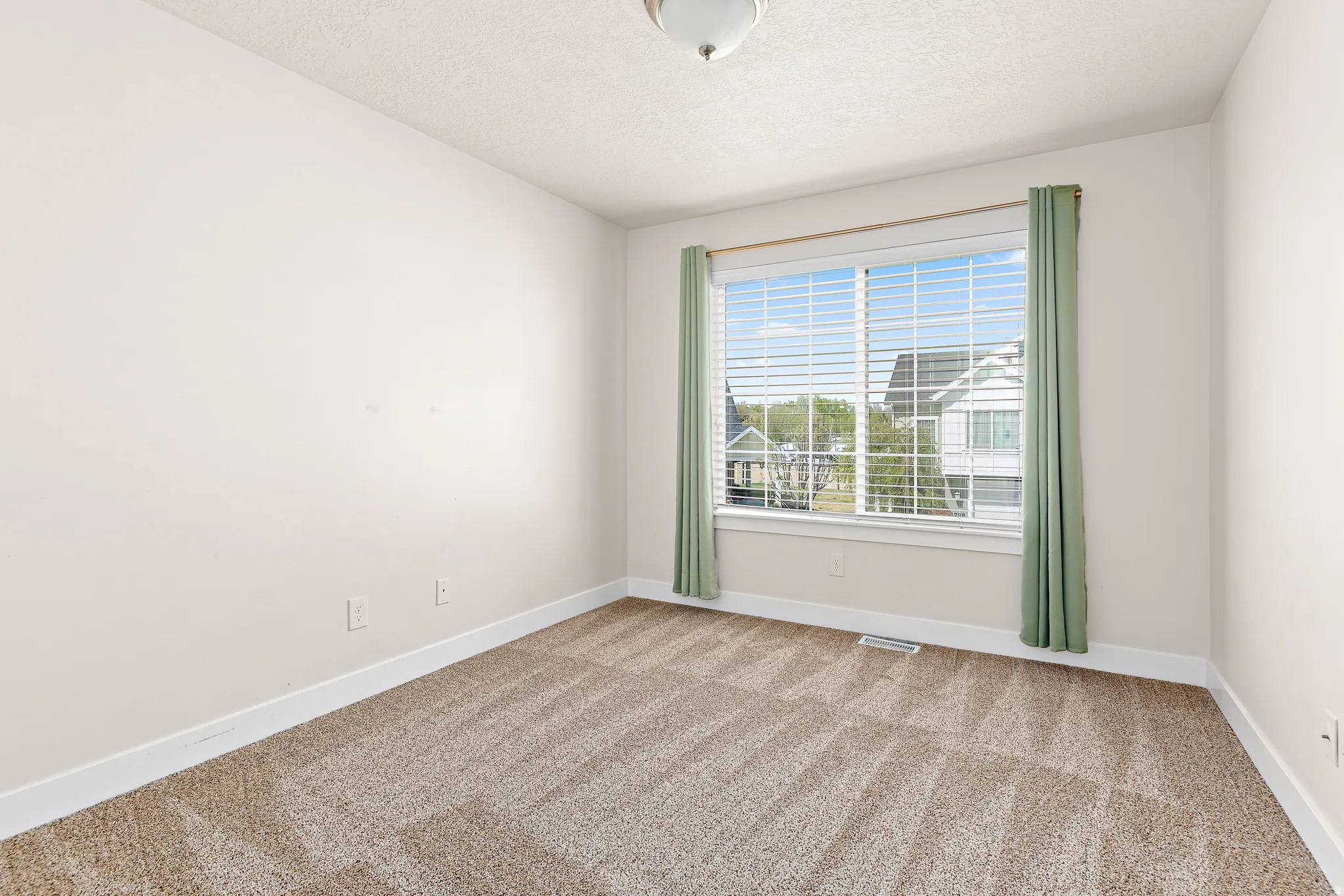 Unfurnished room with light carpet and a textured ceiling