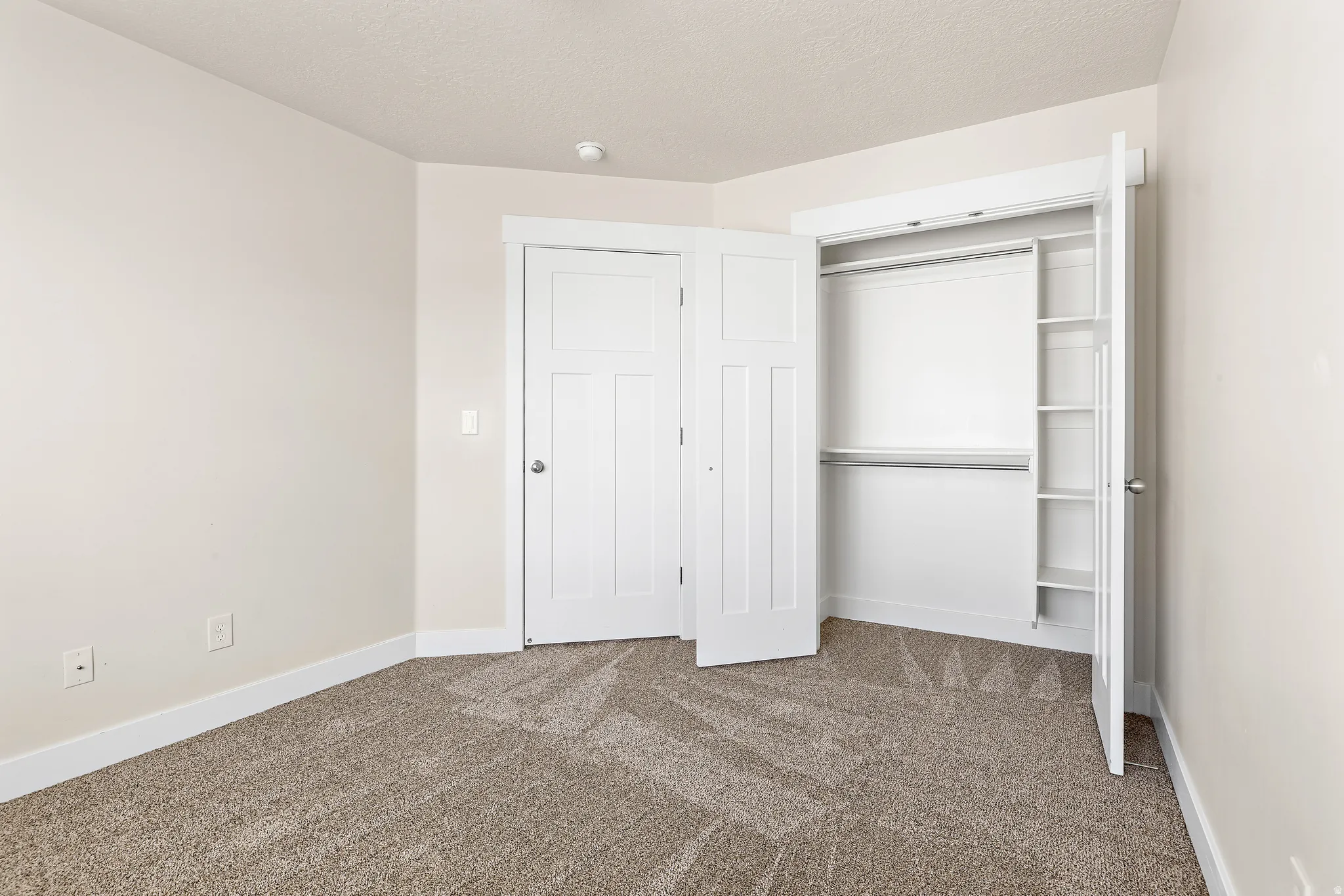 Unfurnished bedroom with dark carpet, a closet, and a textured ceiling