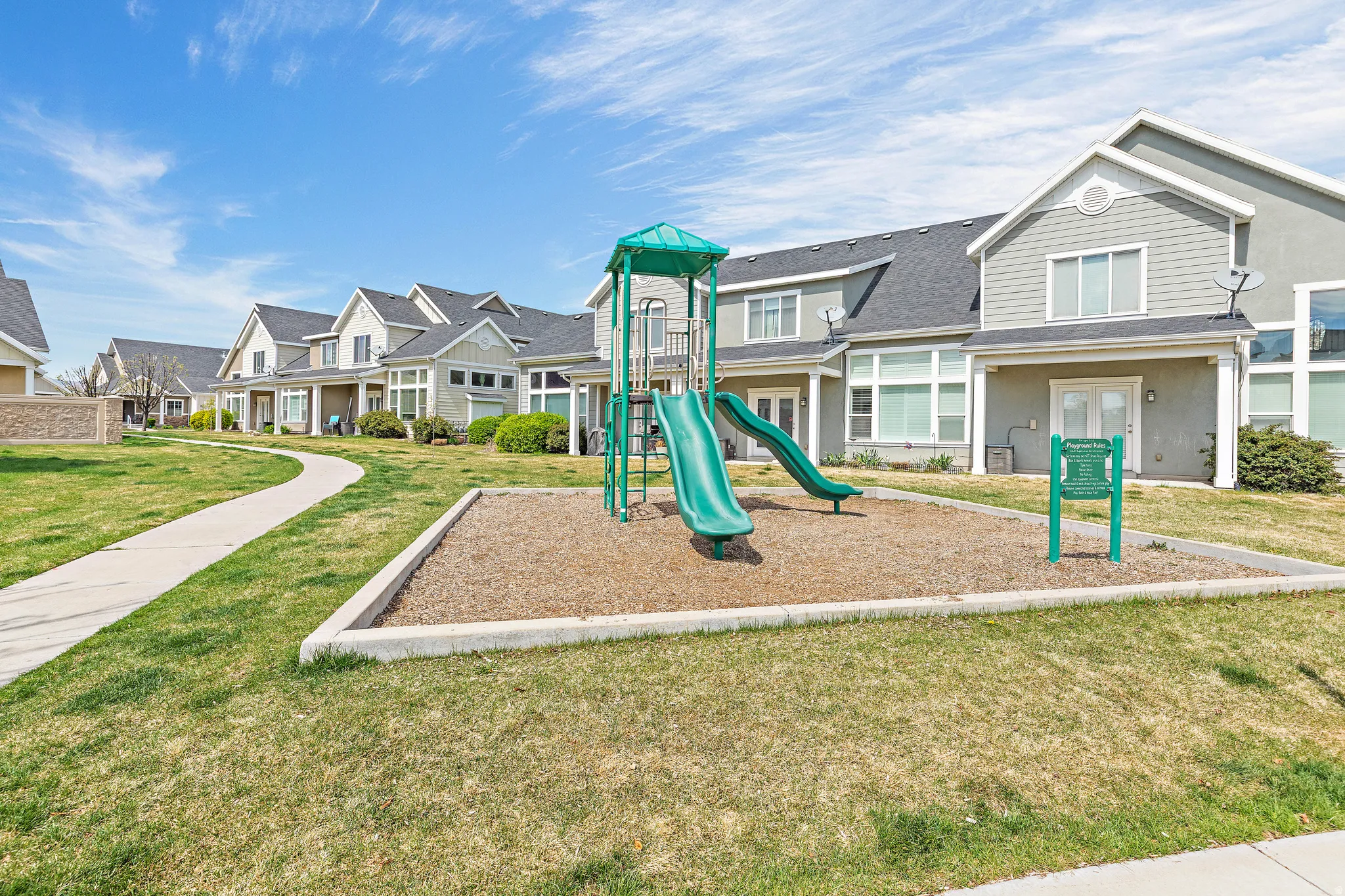 Community jungle gym with a residential view, a lawn, and covered porch