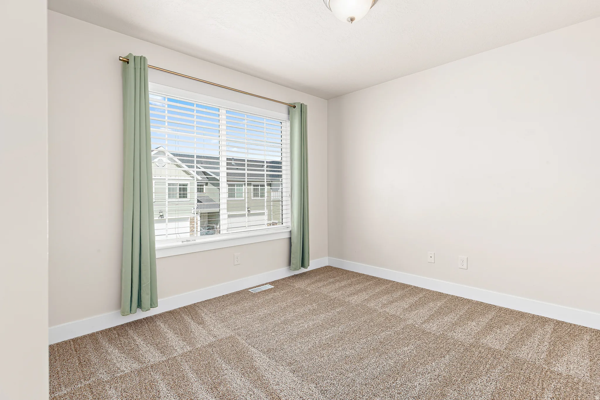 Spare room featuring carpet flooring and baseboards