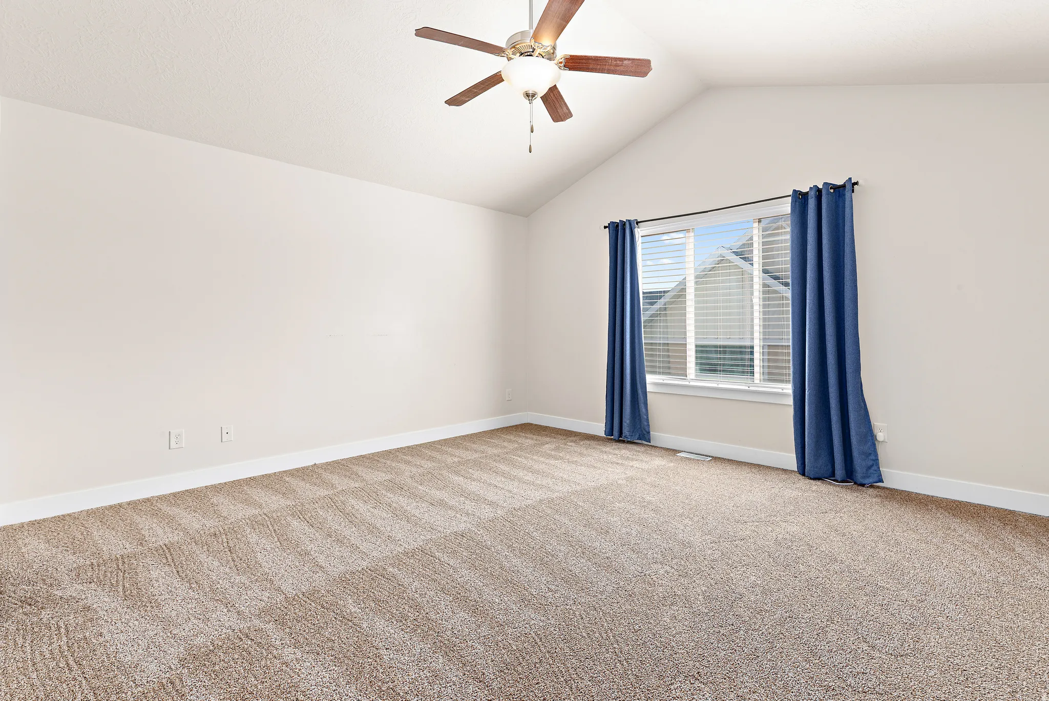 Empty room featuring light colored carpet and a ceiling fan